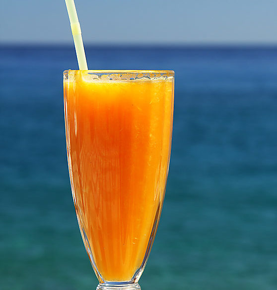 Sok pomarańczowy i morze, Kreta, szklanka soku na tle morza
