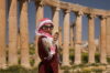 Mais zaprasza do Dżerasz, Jordania, jordańska dziewczyna z kwiatkiem w ruinach starożytnego Dżerasz