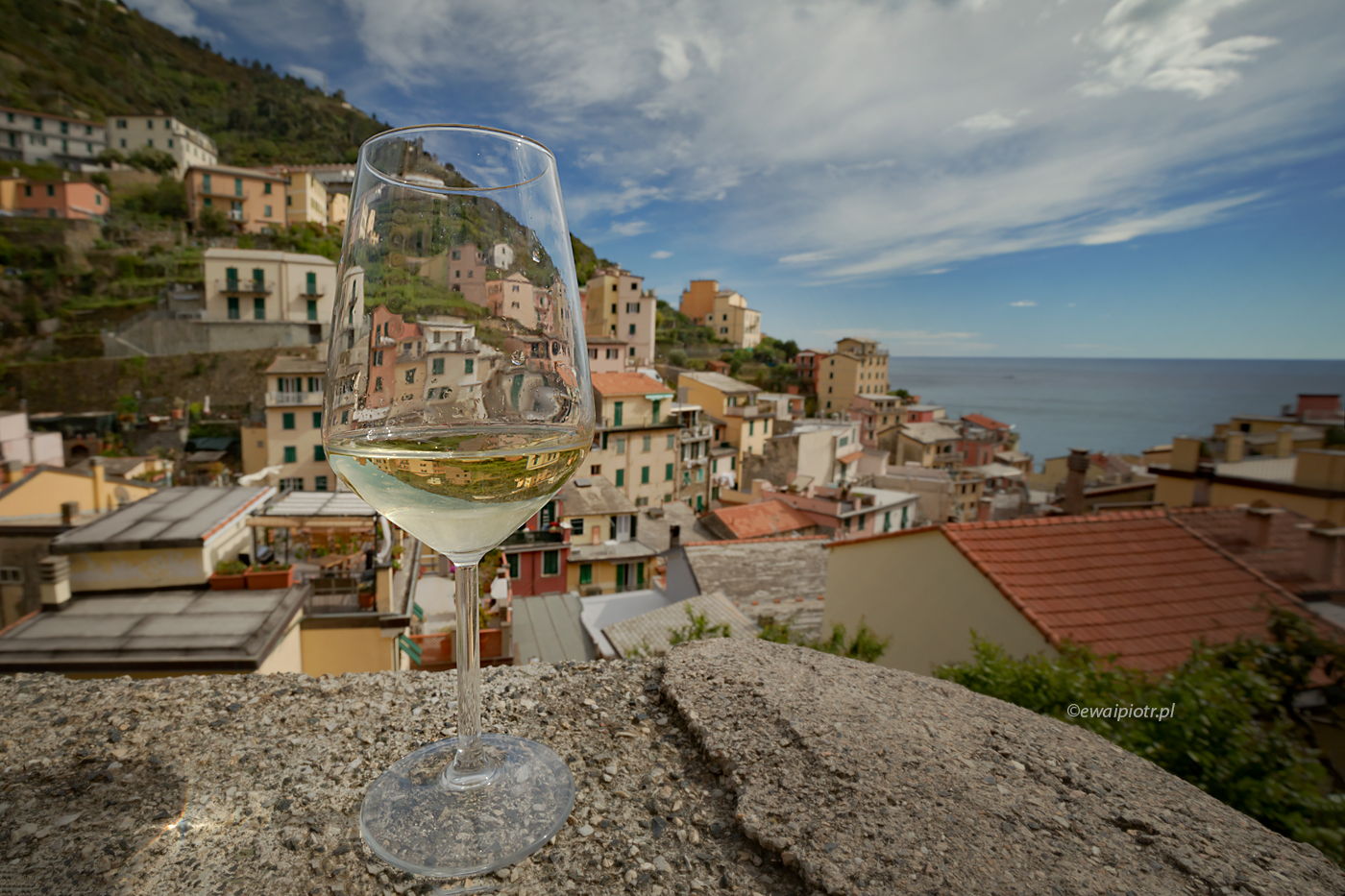 Riomaggiore przez szkło, Cingue Terre, Włochy, kieliszek wina i widok na miasteczko, fotowyprawa